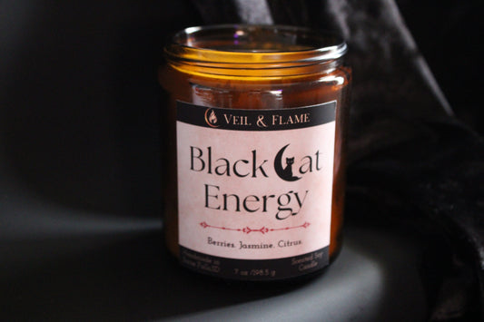 Candle jar labeled 'Black Cat Energy' by Veil & Flame on a dark background