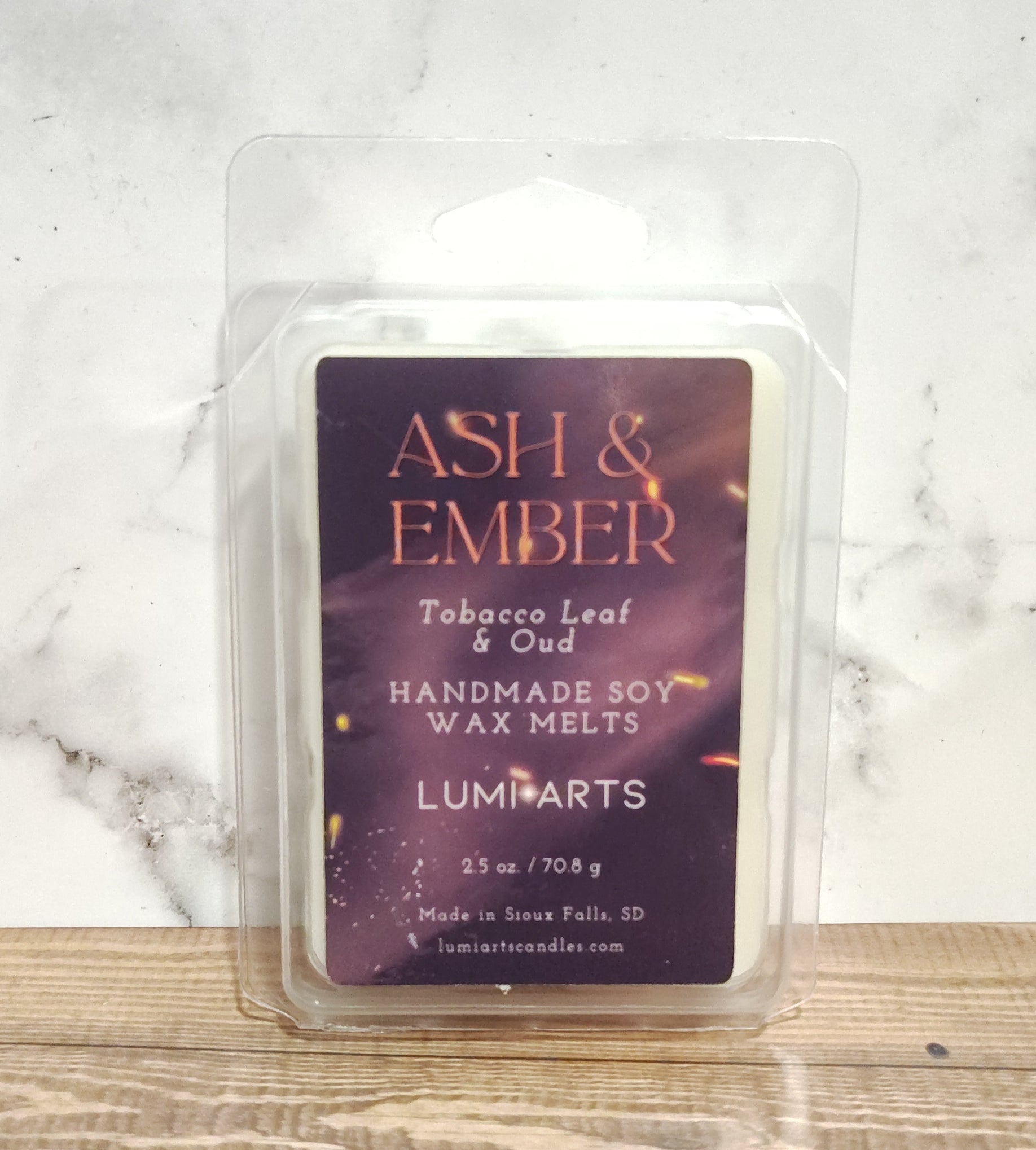 Wax melt packaging on a marble and wooden surface