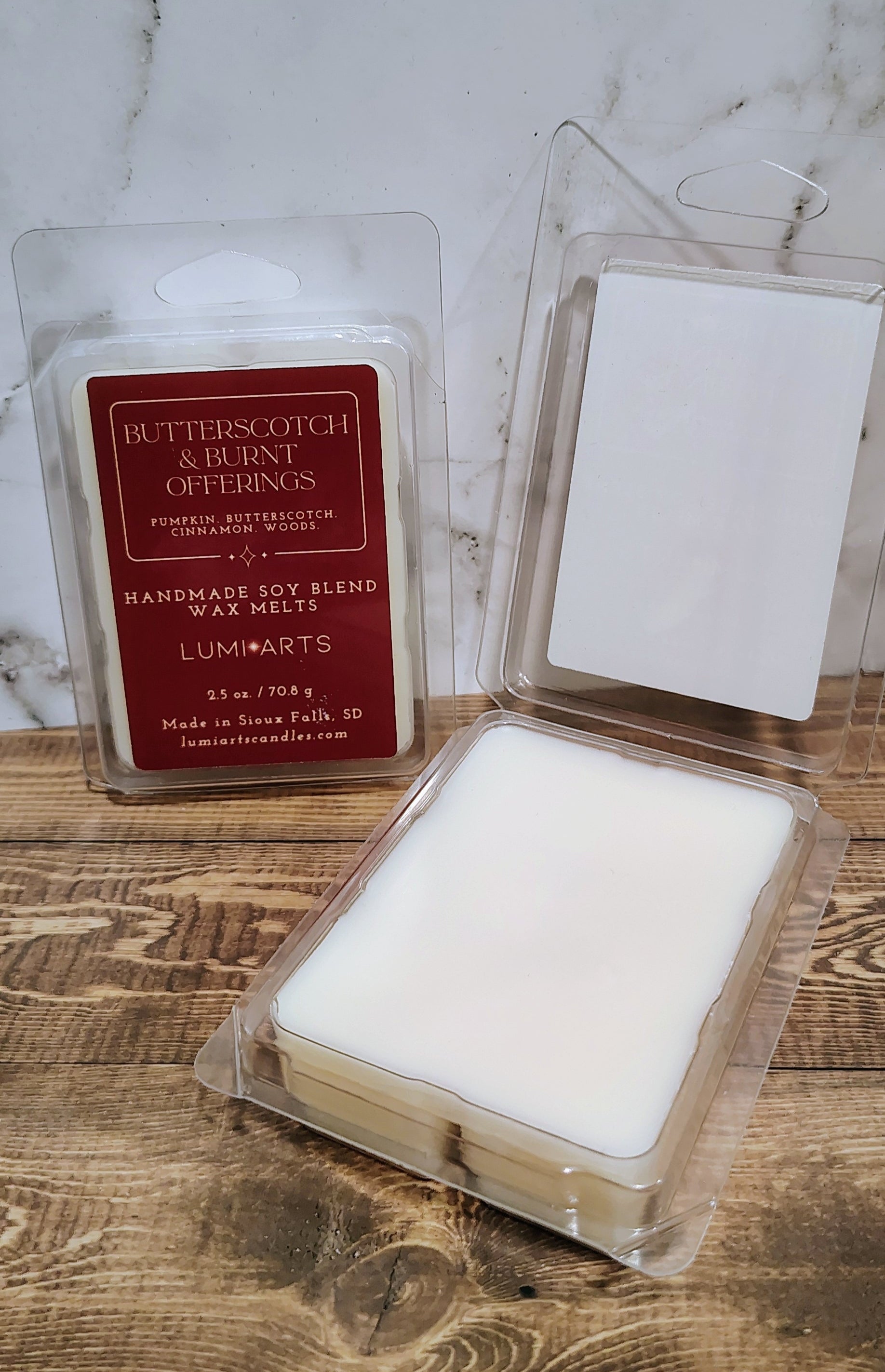 Butterscotch and Vanilla Scents candle packaging on a wooden surface with marble background