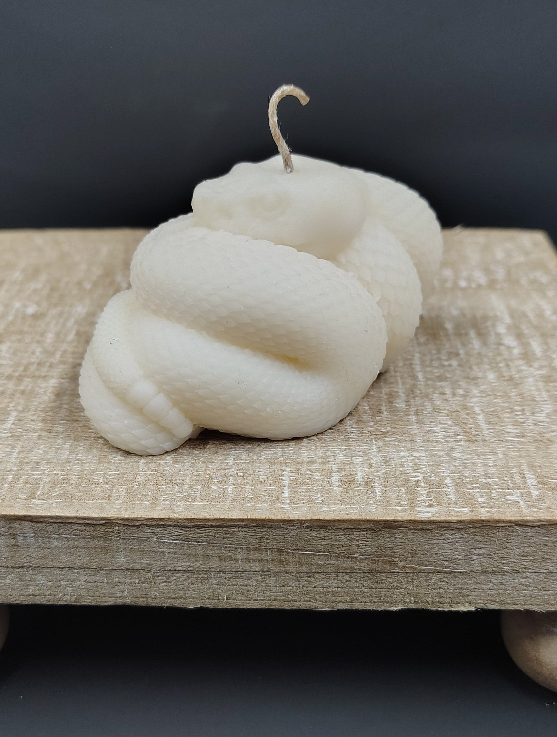White skein of yarn on a wooden surface with a dark background