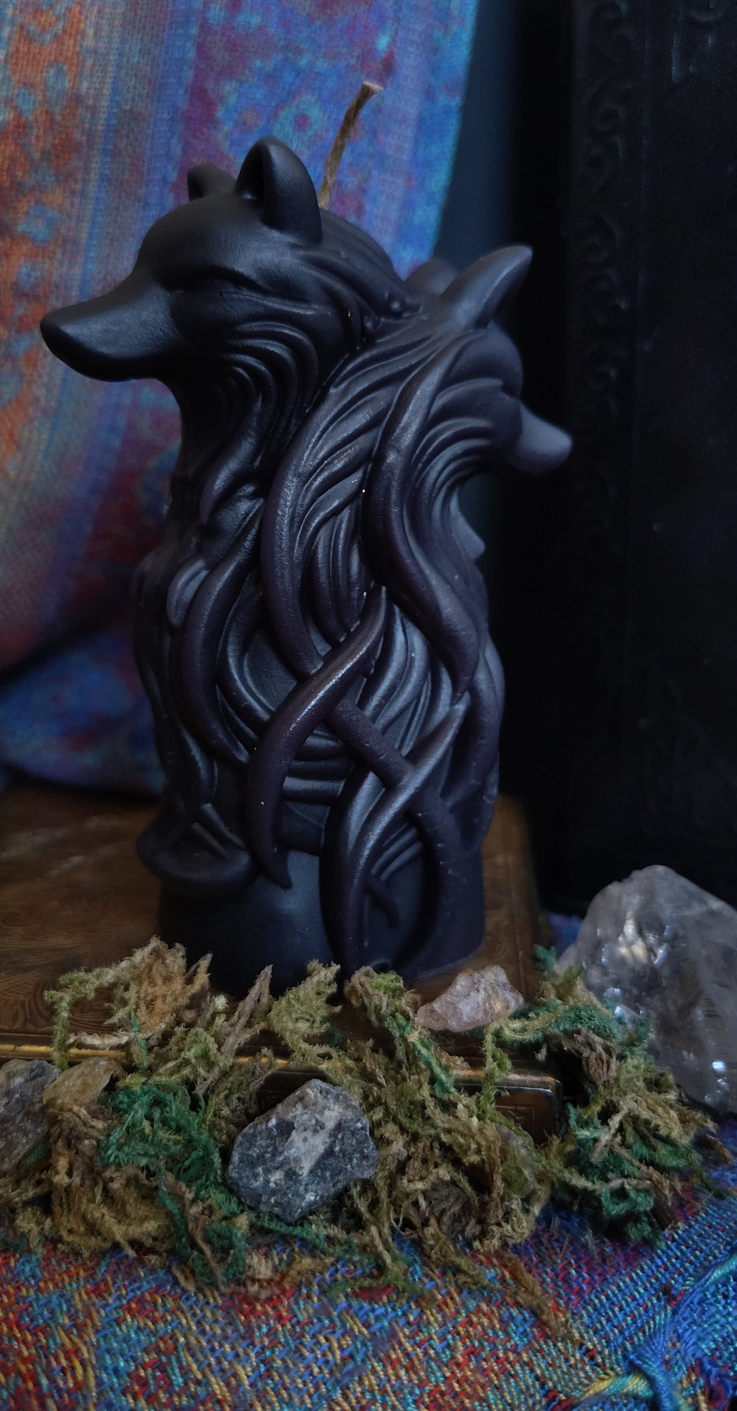 Decorative wolf head sculpture on a colorful fabric background