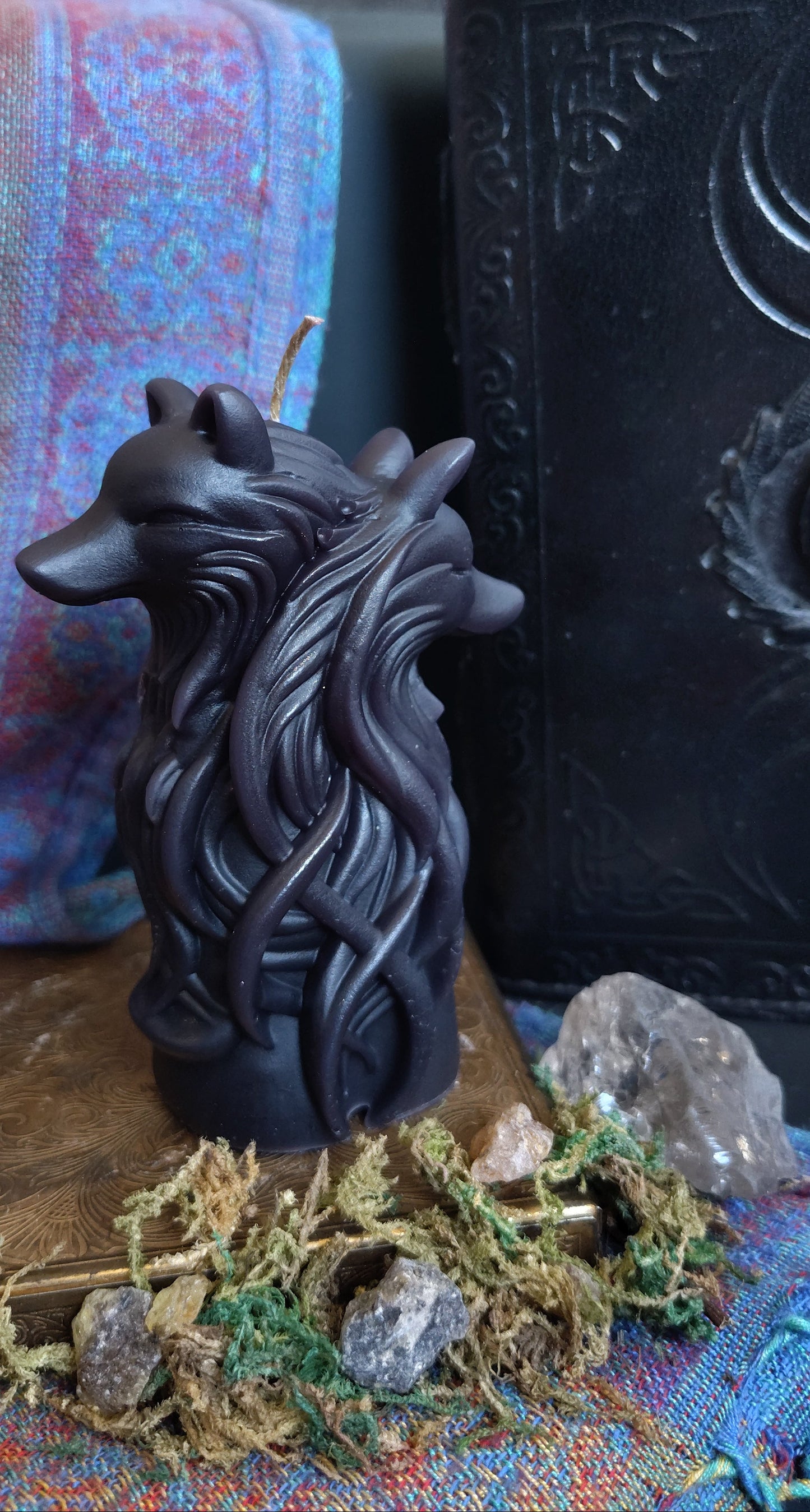 Decorative item with a dual wolf head design on a textured surface