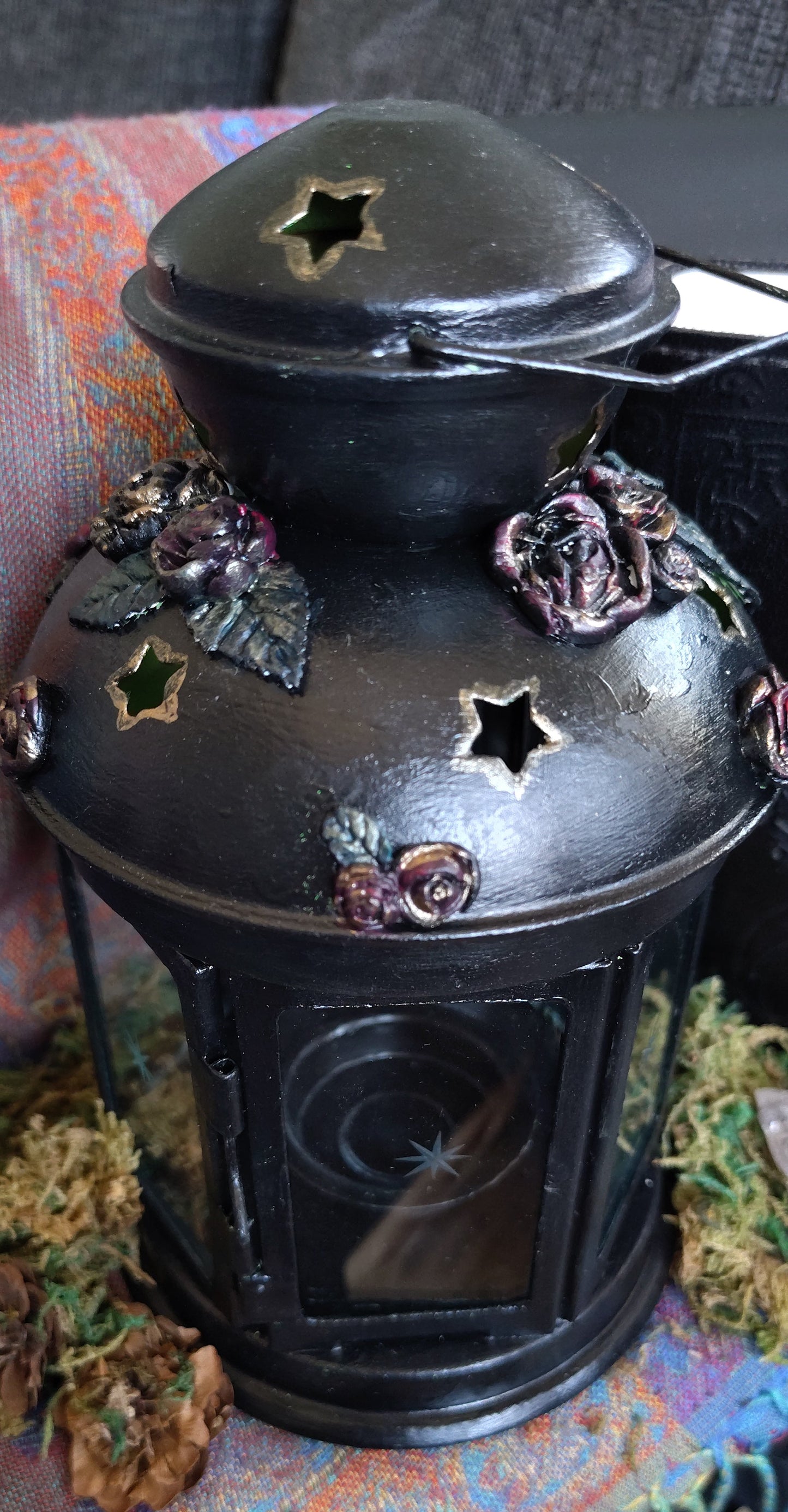 Decorative lantern with star and flower patterns on a colorful fabric background