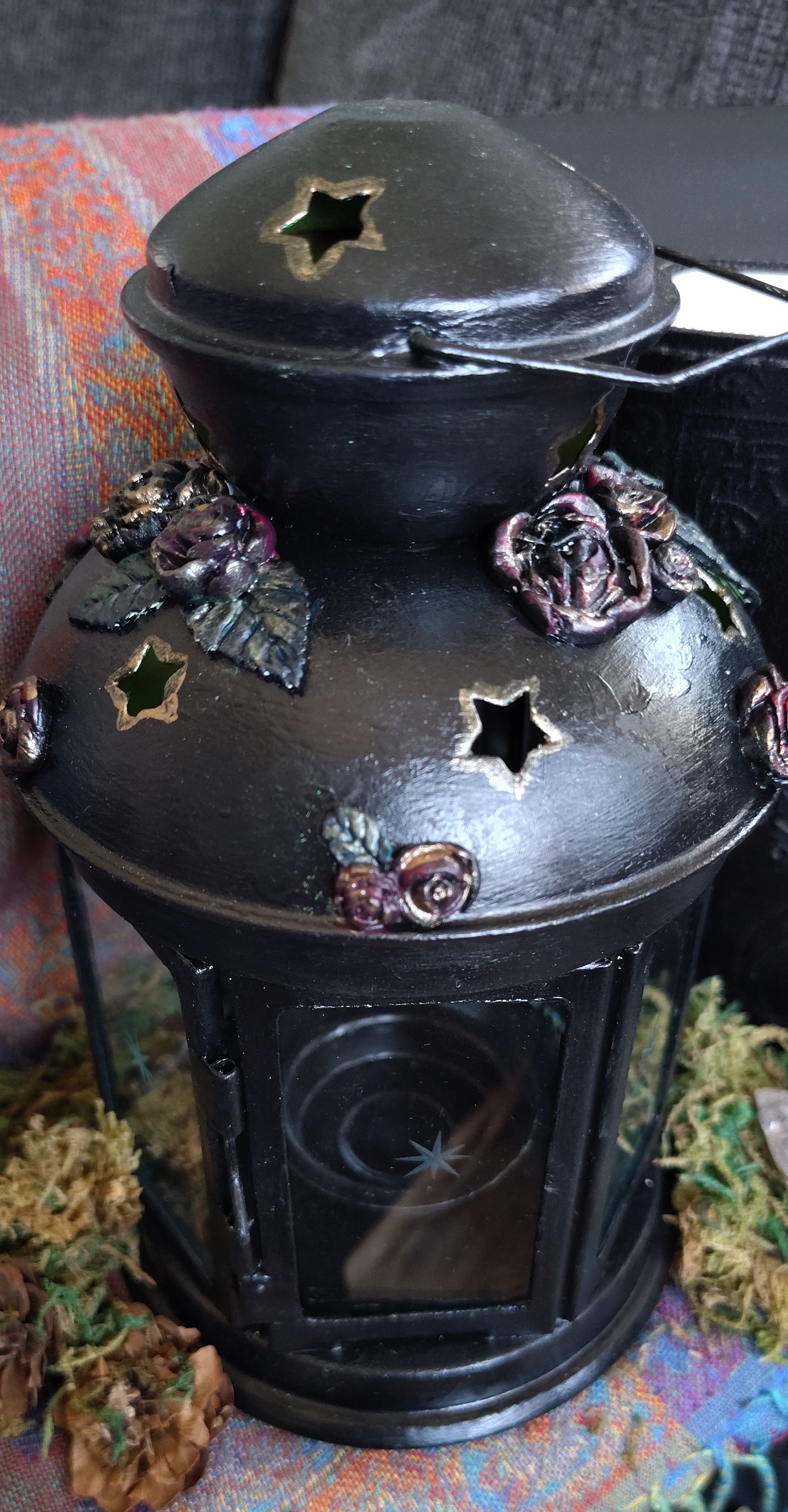 Decorative lantern with star and flower patterns on a colorful fabric background