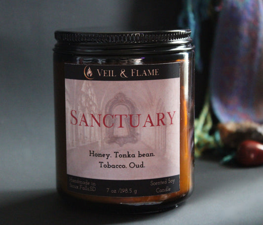 Candle jar labeled 'Sanctuary' by Veil & Flame with a dark background