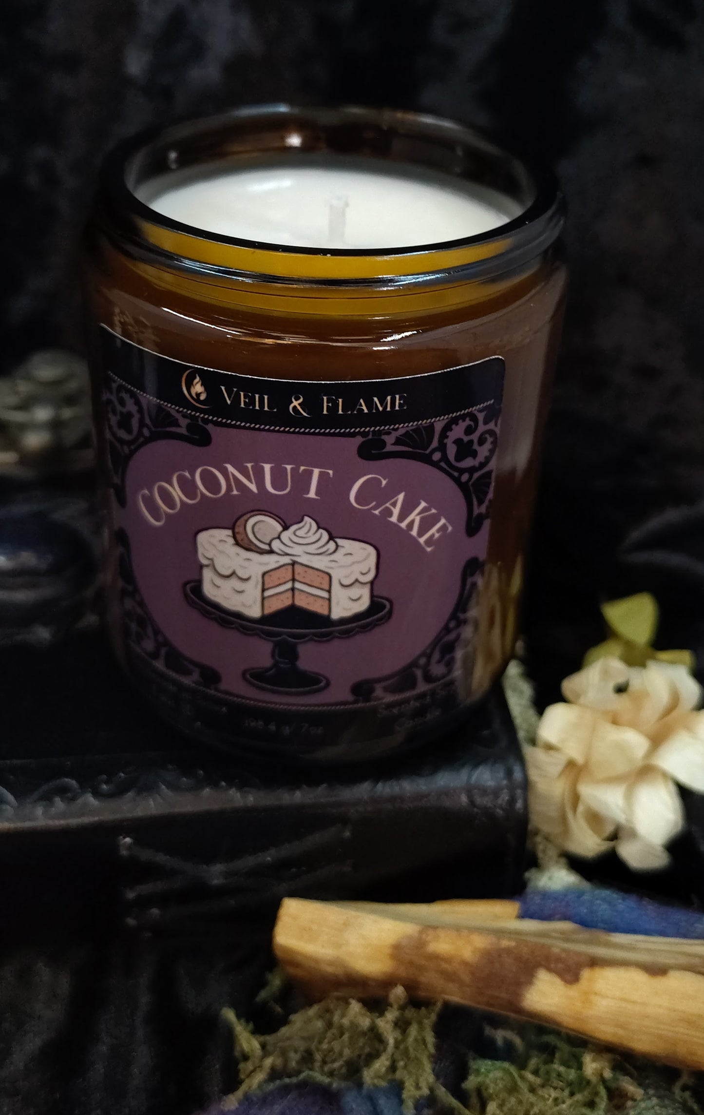 Coconut cake scented candle in a decorative jar with a label on a dark background.